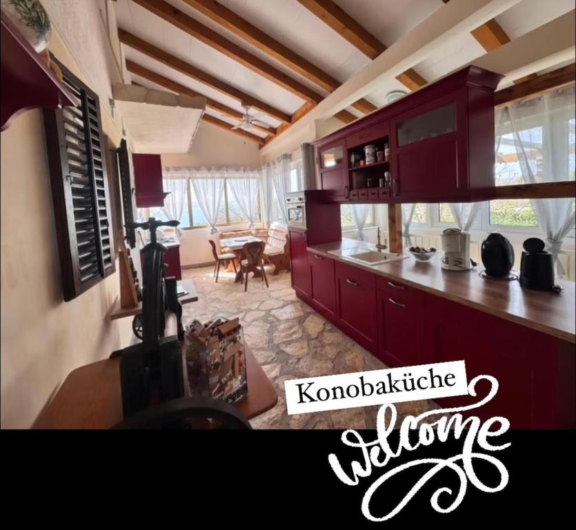 a kitchen with red cabinets and a living room at Ferienhaus in Kroatien für 9 Personen in Maslenica