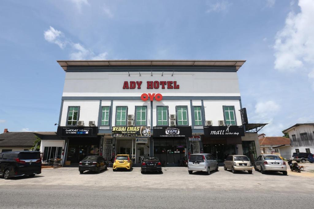 a large building with cars parked in a parking lot at Hotel O Ady Hotel in Kuala Terengganu