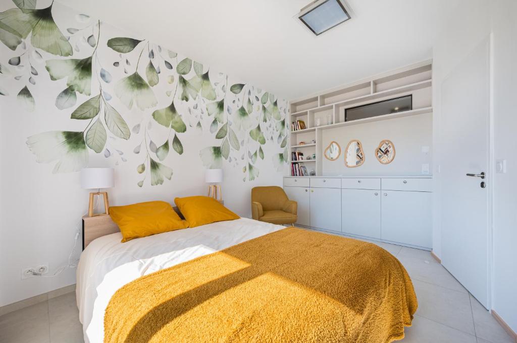 une chambre avec un lit avec une couverture jaune dans l'établissement Magnifique T3 wifi, garage et climatisation à 5 min de la plage, à Beaulieu-sur-Mer