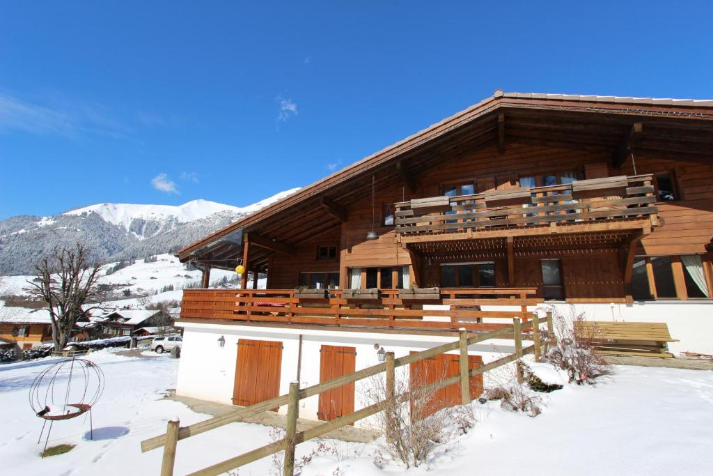 a large wooden building with snow on the ground at La Malandre in Chateau-d'Oex