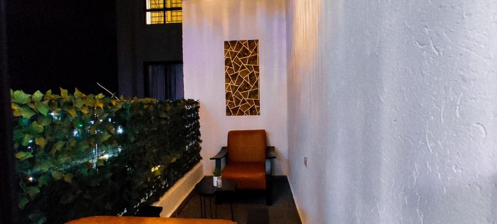a balcony with two orange chairs and a wall at Serene Hills Home in Nairobi