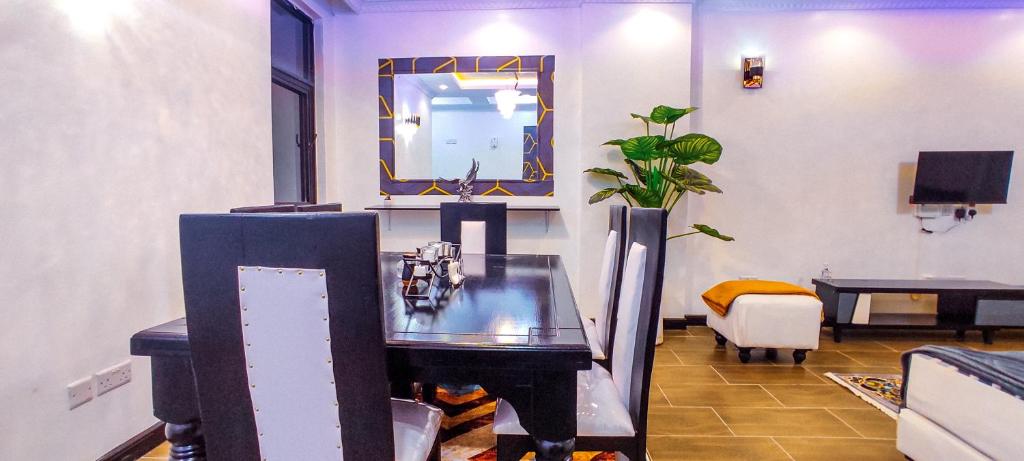 a living room with a glass table and a mirror at Serene Hills Home in Nairobi