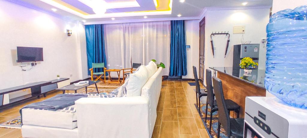a living room with white chairs and a table and a room at Serene Hills Home in Nairobi
