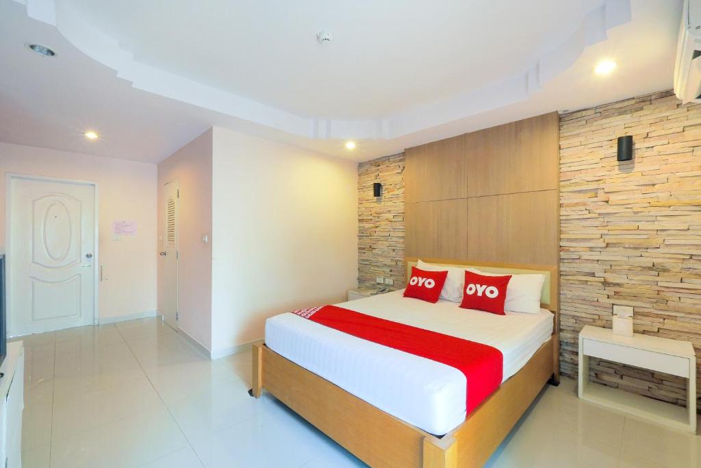 a bedroom with a large bed with red pillows at OYO 926 Sydney Resort in Ban Don Pho