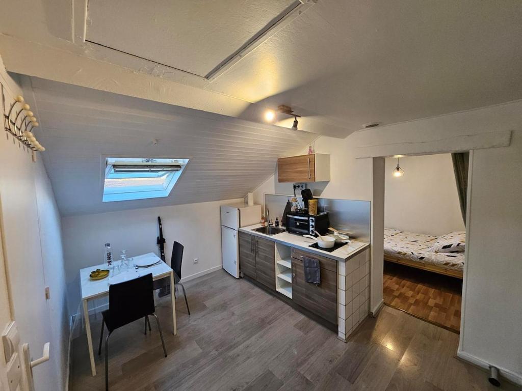 グルノーブルにあるAppartement - Grenoble - Calmeのキッチン、デスク、ベッドが備わる客室です。