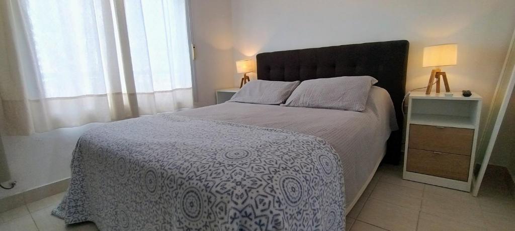 a bedroom with a bed with a blue and white blanket at Precioso departamento en Paraná. Zona Centro in Paraná