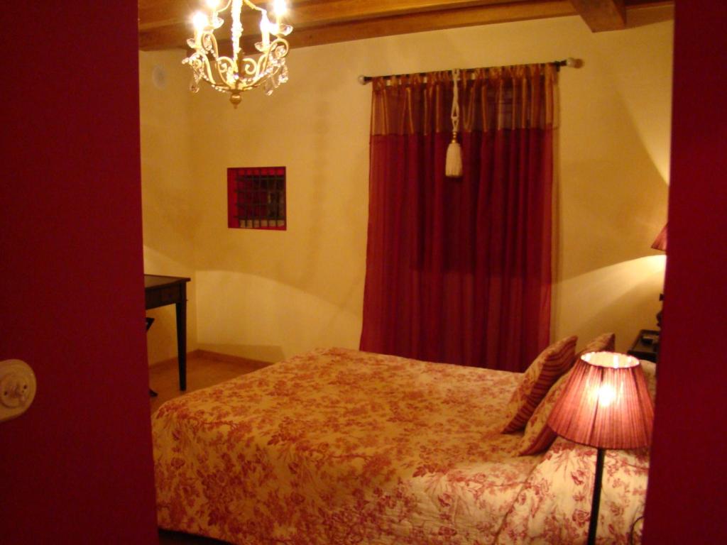 1 dormitorio con 1 cama con cortina roja y lámpara en A Casa de Mañas, en Mondoñedo
