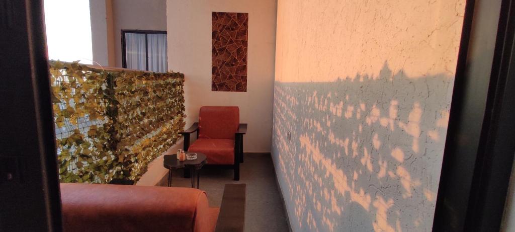 a room with a red chair and a wall at Serene Hills Home in Nairobi