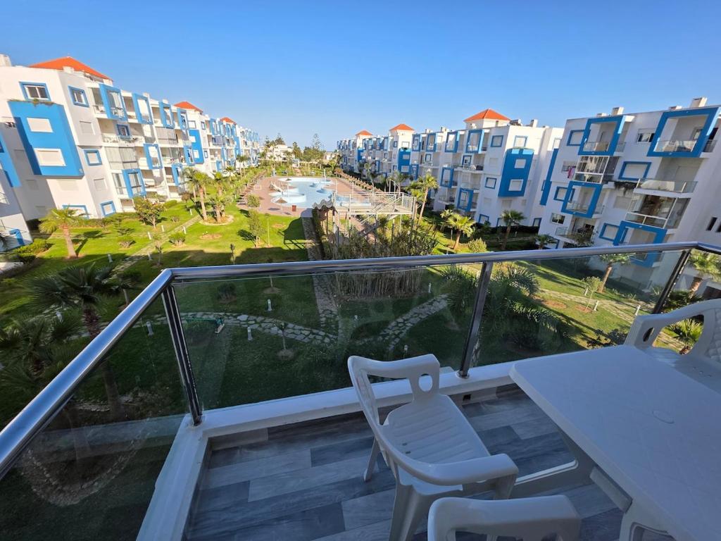 a balcony with a table and chairs and some buildings at Cabo Apparte Piscine & Panoramique View K17 in Cabo Negro