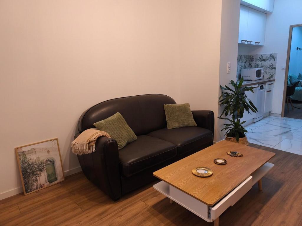 un salon avec un canapé et une table basse dans l'établissement L'échappée verte, à Amiens