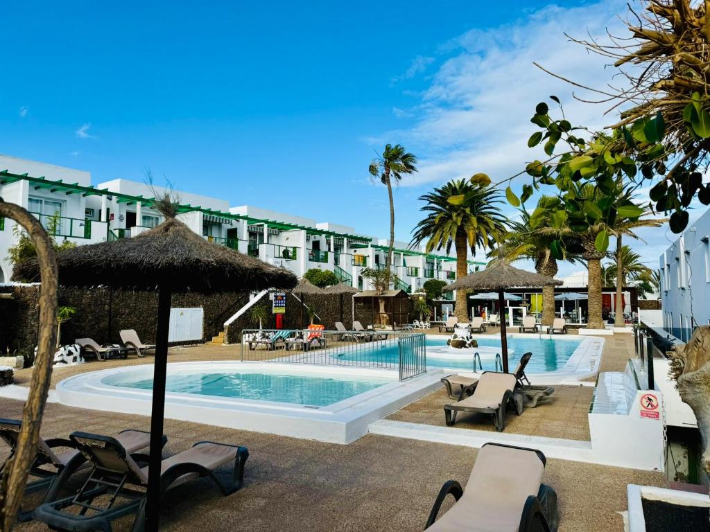 a pool at a resort with chairs and umbrellas at Little Gem in Matagorda