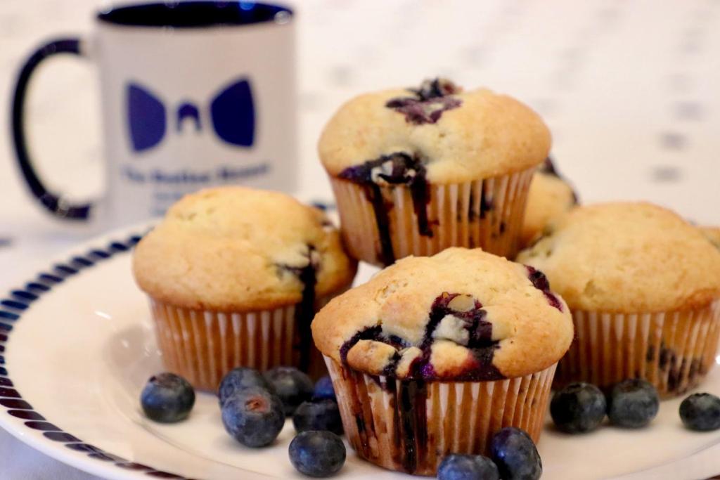 a plate with muffins and blueberries and a cup of coffee at The Butler House Bed & Breakfast in Niagara Falls