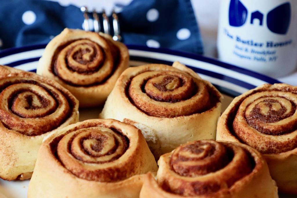 a blue and white plate with cinnamon rolls on it at The Butler House Bed & Breakfast in Niagara Falls