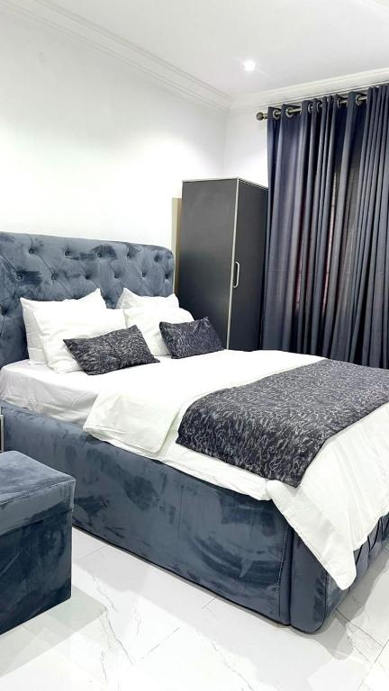 a bedroom with two beds with blue and white sheets at Blueocean Apartment in Benin City