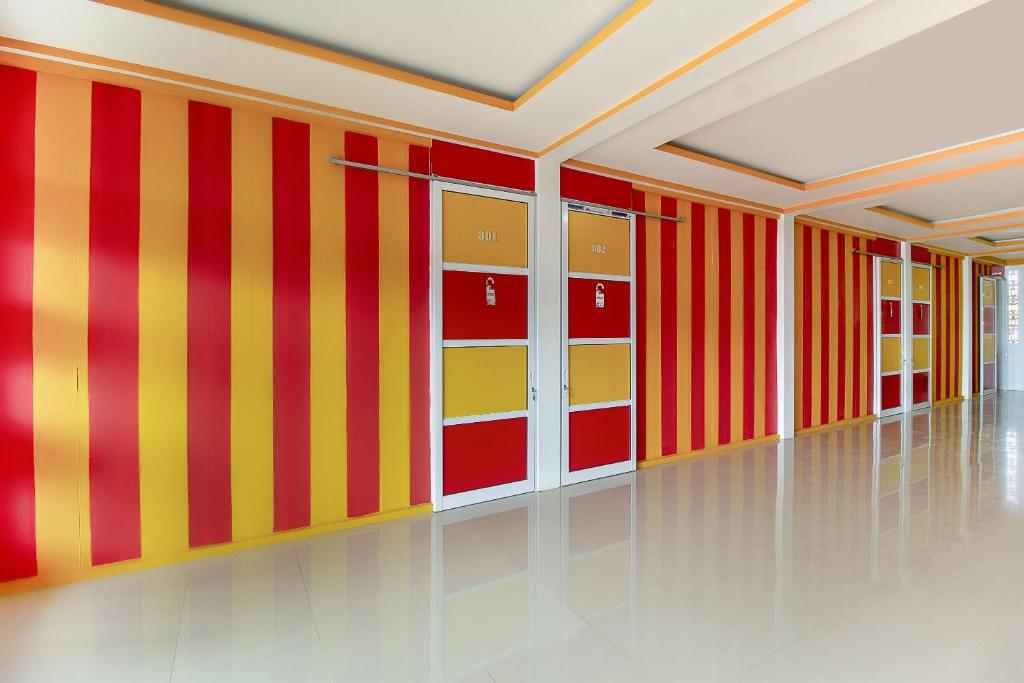 een lege kamer met rode en geel gestreepte muren bij Restu Inn in Lampung