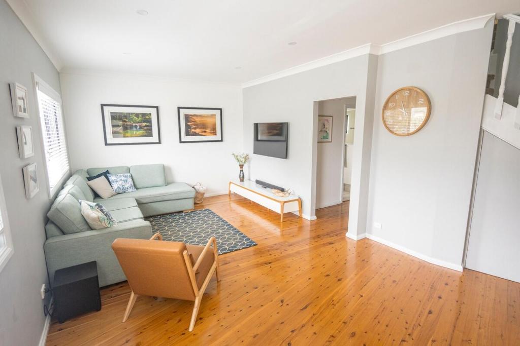 a living room with a couch and a table at Long Jetty Beach House in Long Jetty