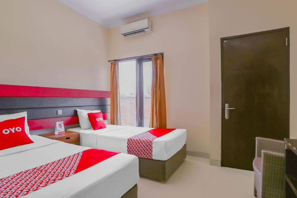 Postel nebo postele na pokoji v ubytování OYO 4012 Ari Beach Inn