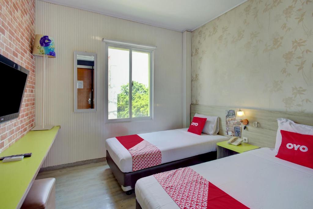 A bed or beds in a room at Collection O Gambir Near Masjid Istiqlal Formerly Aleander Hotel