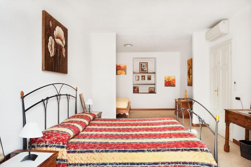 a bedroom with a bed with a colorful blanket on it at B&B Affittacamere Via del Centro in La Maddalena
