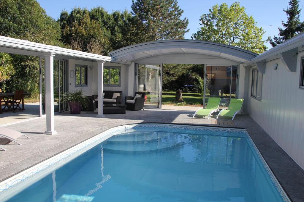 a swimming pool with a patio and a house at Domaine De Meigne in Meigné