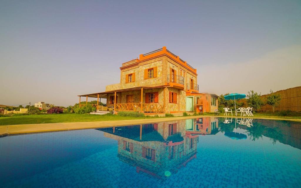 a building sitting next to a pool of water at MesklilHouse in Asilah