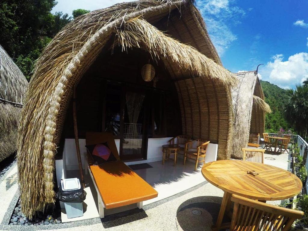 a small hut with a table and chairs and a table at Amed Paradise Warung & House Bali in Amed