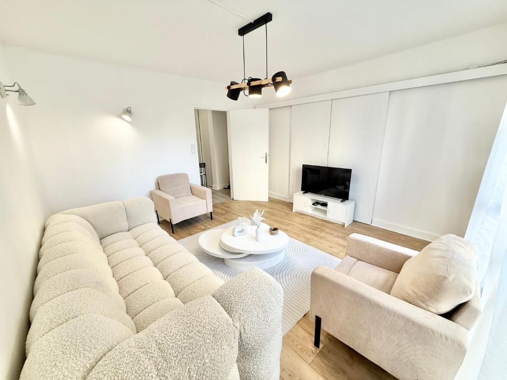 un salon avec un canapé et une table dans l'établissement Appartement Proche de Paris, ligne 14 à pied, Parking, à Villejuif