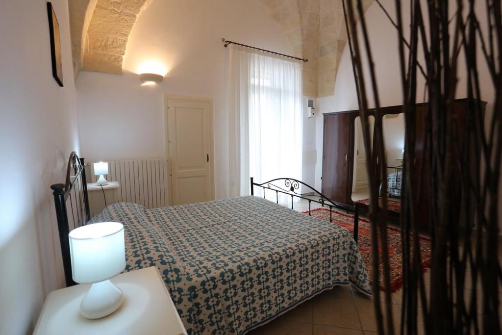 - une chambre avec un lit et une table avec une lampe dans l'établissement Appartamento Sant'Antonio, à Castro di Lecce