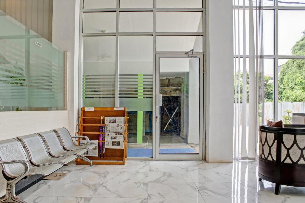 a living room with a chair and a large window at Hotel O Permata Inn in Banjarmasin