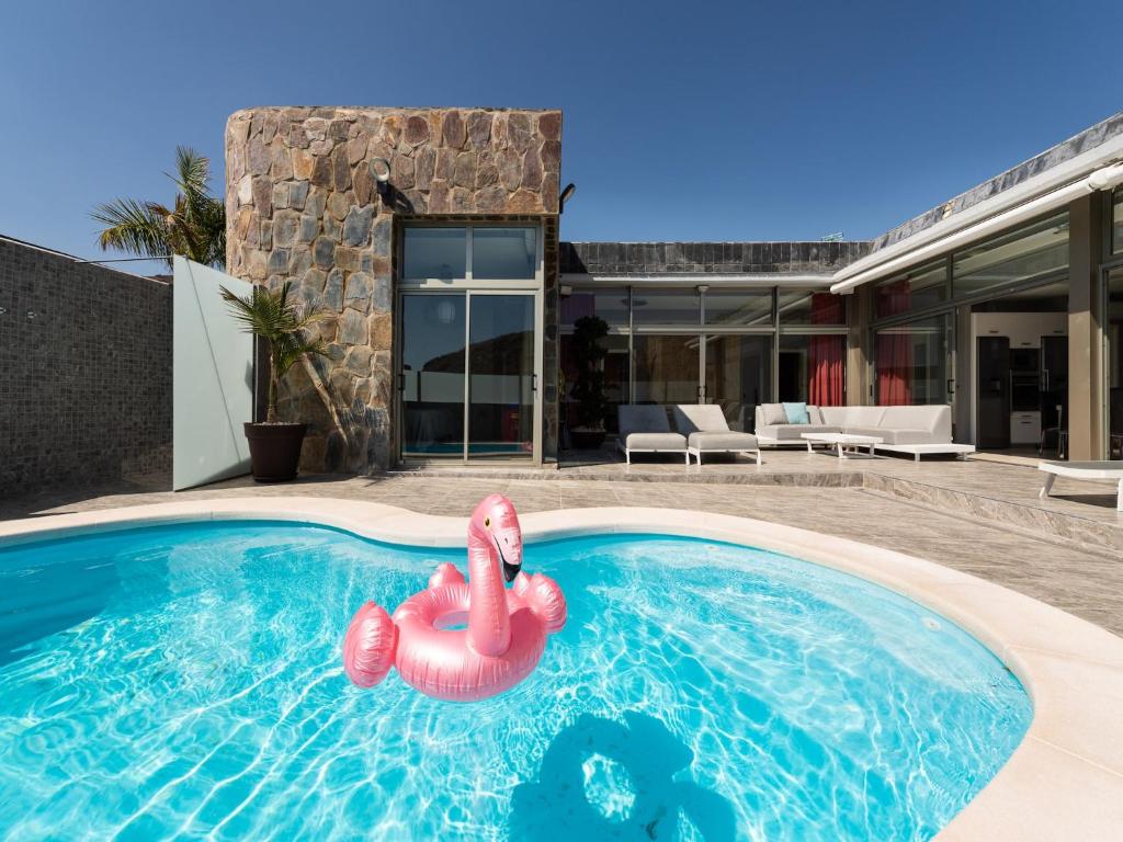 una piscina con fenicottero gonfiabile di fronte a una casa di Villa in Anfi Tauro near Beach & Golf a Mogán