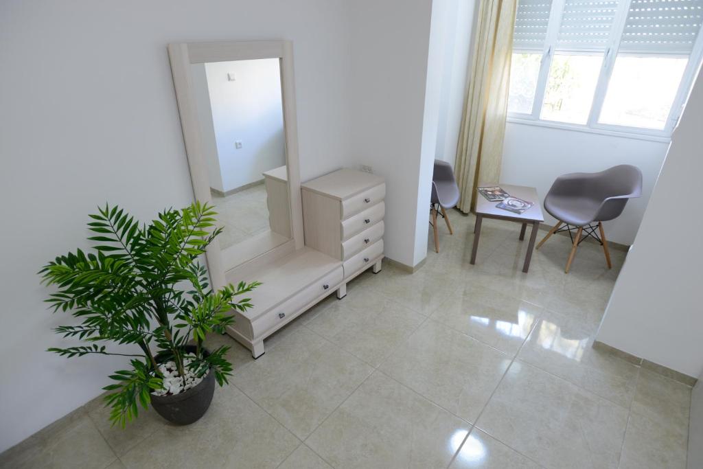 a room with a mirror and a dresser and a plant at Olga Beach Apartments in Haifa
