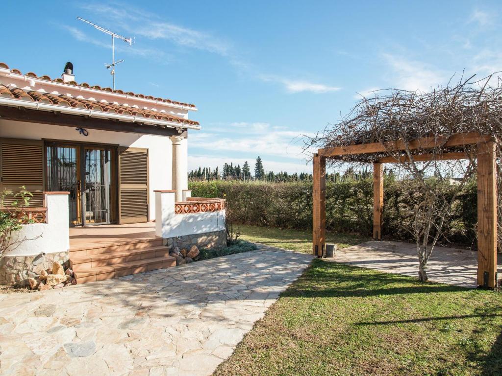 un patio trasero de una casa con pérgola en Belvilla by OYO Bon Relax II45 en Sant Pere Pescador