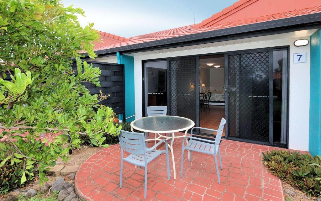 eine Terrasse mit einem Tisch und Stühlen auf einer Backsteinterrasse in der Unterkunft Villa 7 1 Pebble Beach Drive Coral Cove in Elliott Heads
