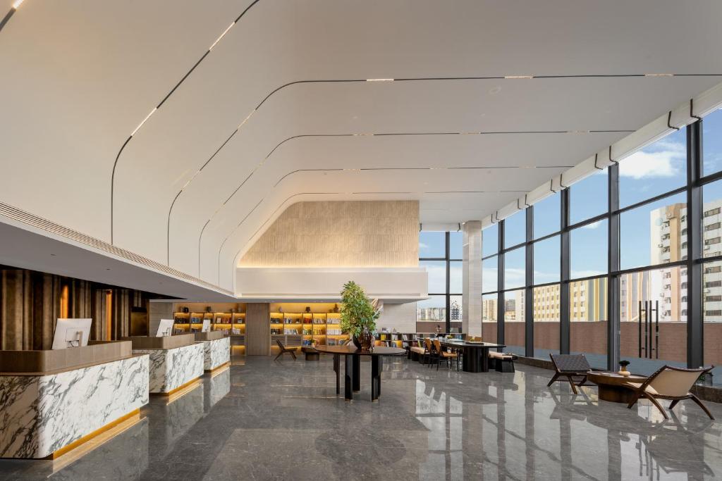 a lobby with a table and chairs and windows at Atour Hotel Guangzhou Railway Station University of Chinese Medicine - Complimentary Self-Service Laundry in Guangzhou