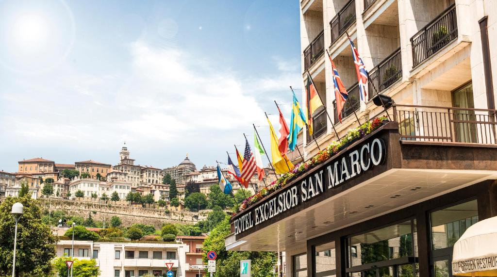 a sign for a hotel with flags on a building at Hotel Excelsior San Marco in Bergamo