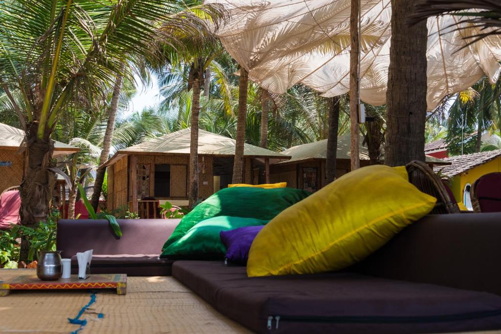 a couch with colorful pillows sitting on a patio at Jardim a Mar in Agonda