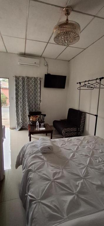 - une chambre avec un lit, un canapé et un lustre dans l'établissement Apartamento Moderno y Privado, à Santa Ana