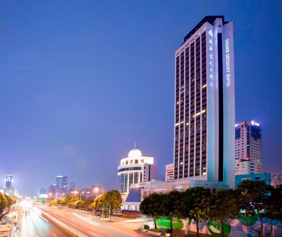 a city skyline with a tall building and a street at Grand Skylight Hotel Shenzhen (Huaqiang NorthBusiness Zone) in Shenzhen