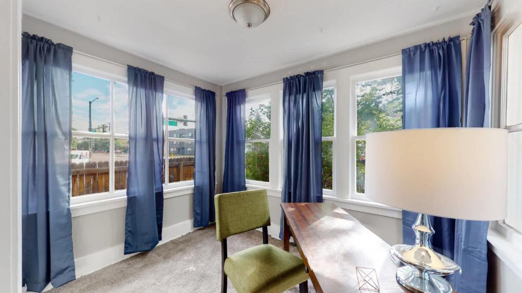 a dining room with blue curtains and a table and a lamp at Chic Denver Family Retreat Free Parking & Prime Location in Denver