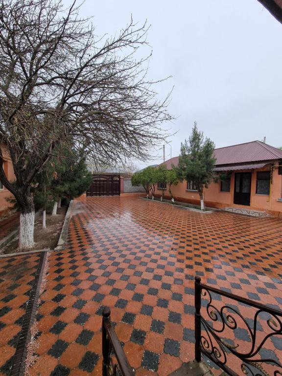 Guest House Венеция في Türkistan: فناء من الطوب ذو أرضية مربعة الشكل أمام مبنى