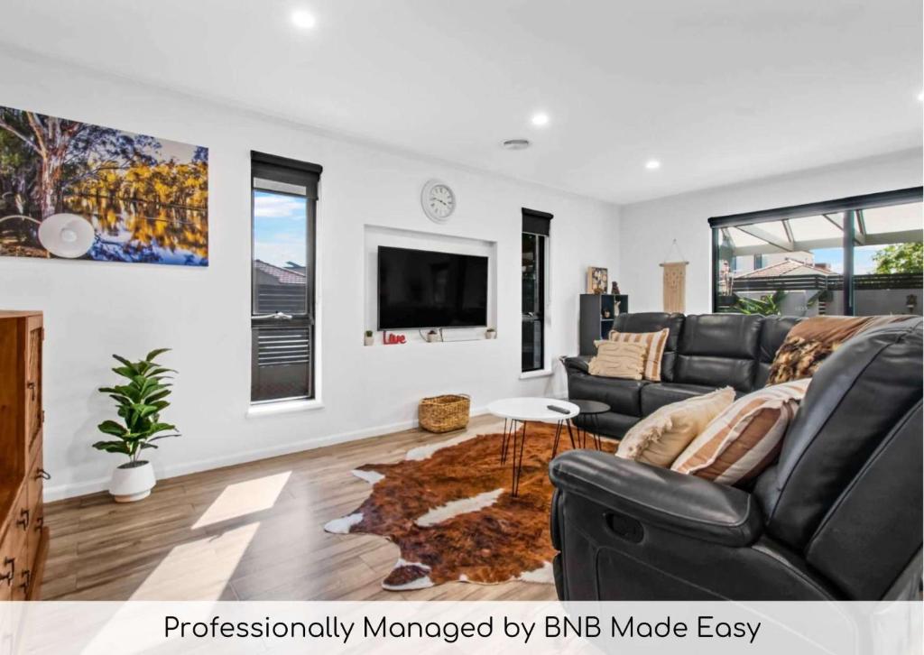 a living room with a couch and a tv at Galing Place - Close to CBD, Pet Friendly in Wagga Wagga
