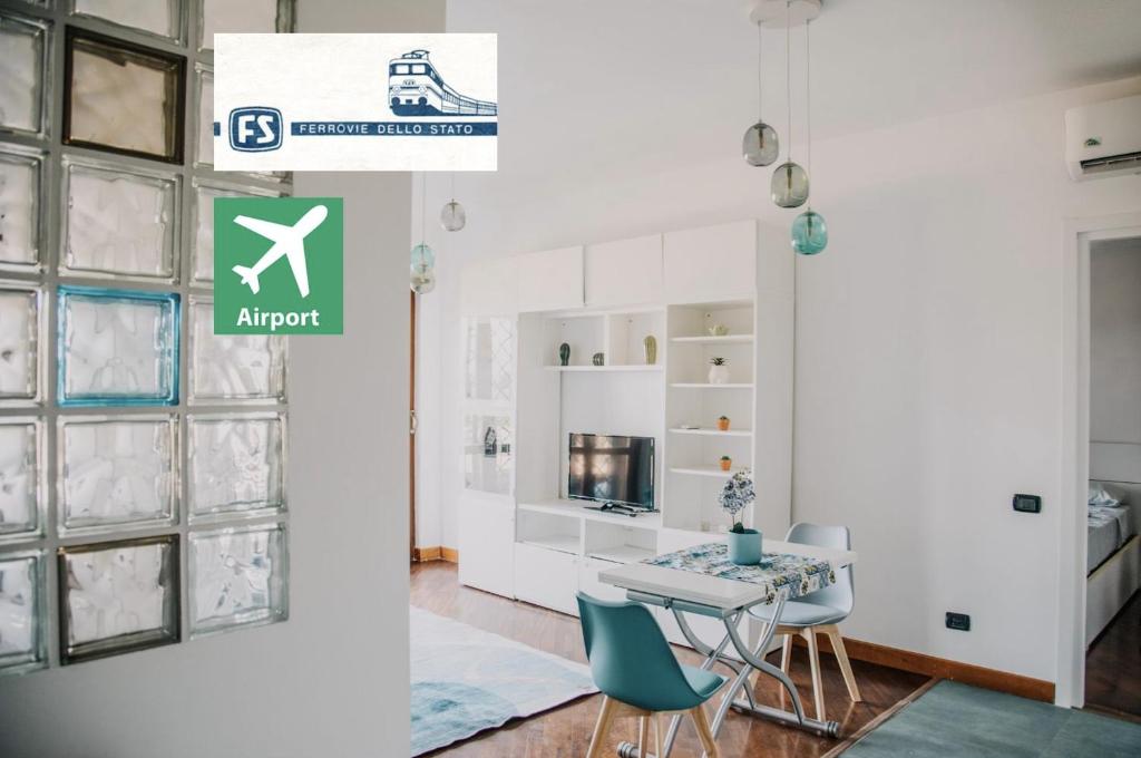 una stanza con tavolo e sedie e un cartello che legge aeroporto di Poccio House a Fiumicino