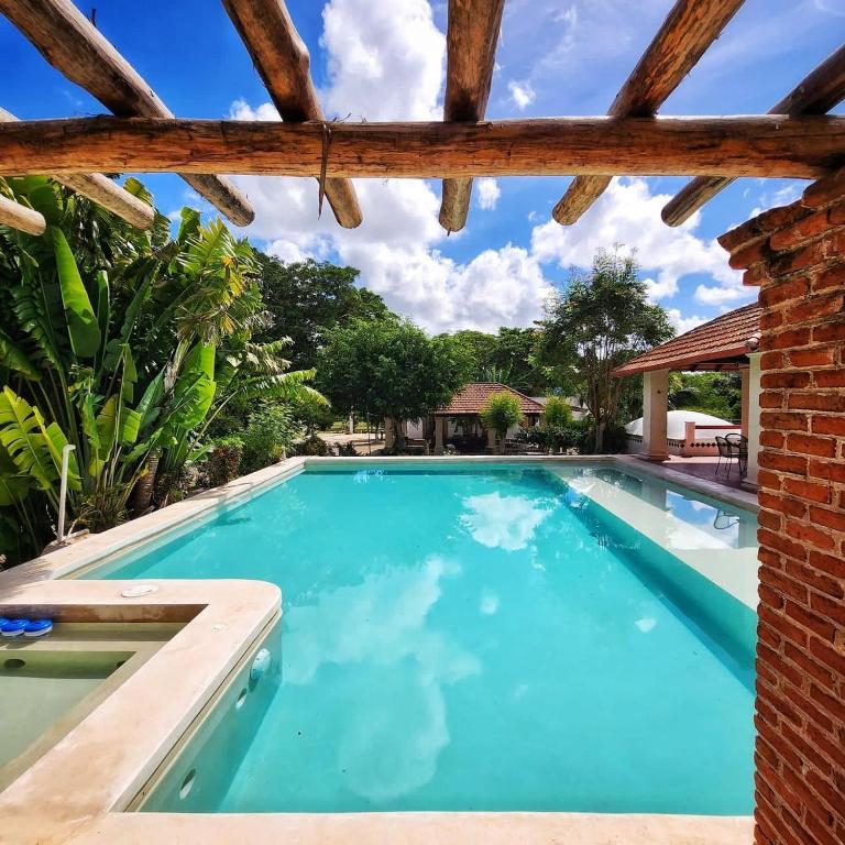 a swimming pool in a house with a brick wall at Hacienda San Antonio in Kanasín