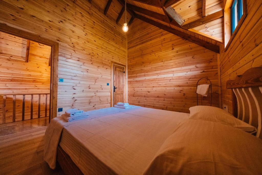 una camera da letto con un letto in una stanza di legno di Kartepe Maşukiye de 2 oda1 salon Özel Havuzlu - Şömineli -Muhafazakar 5 Kişilik Bungalov a Korfez