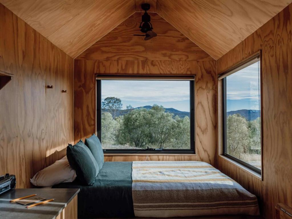 Un dormitorio con una cama y una ventana grande. en Pet Friendly Cabin Surrounded by Wilderness - Gili, en Coleyville