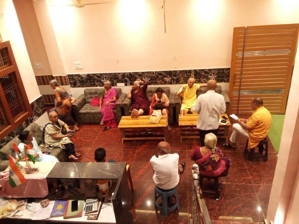 a group of people sitting in a living room at Kaka Guest House in Ayodhya
