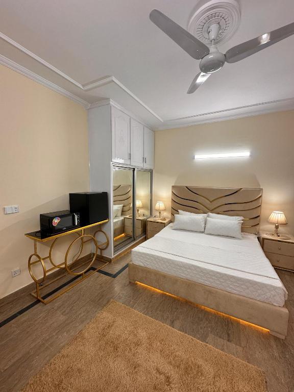 a bedroom with a bed and a ceiling fan at Golden Horizon Suite in Lahore