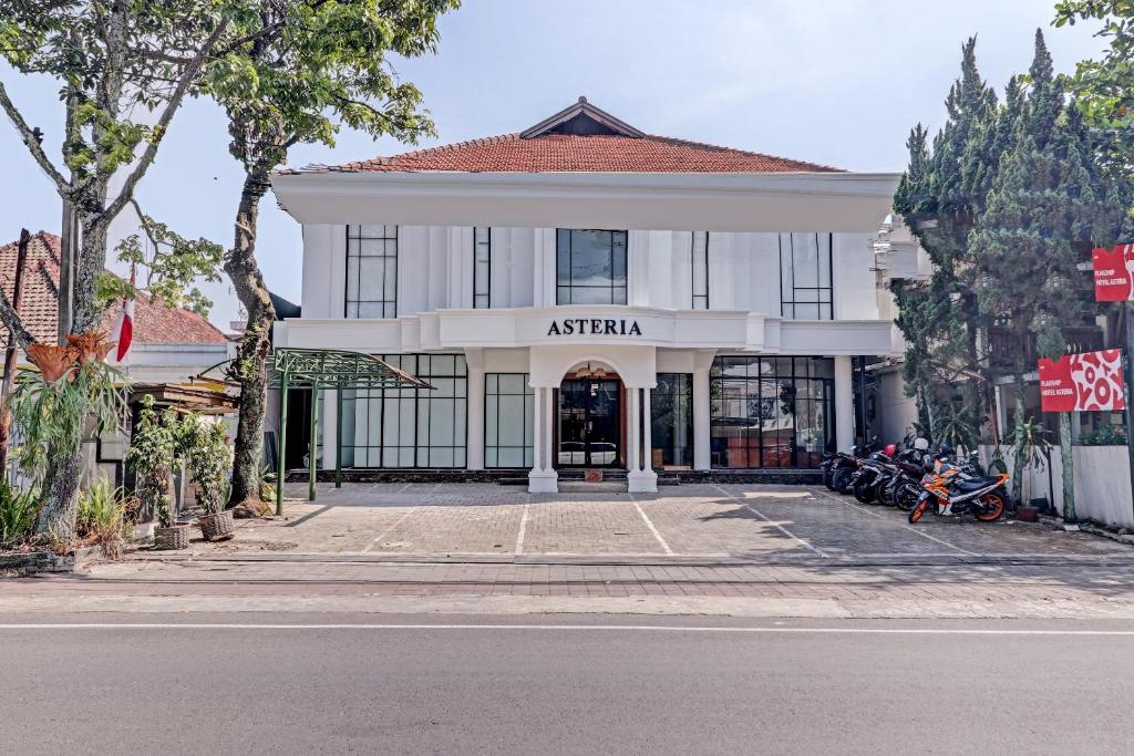a building on a street with motorcycles parked in front of it at Collection O Riau Near Trans Studio Bandung Formerly Asteria Hotel in Bandung