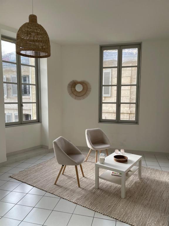 un salon avec deux chaises et une table basse dans l'établissement Appartement intra-muros climatisé coeur historique, à Avignon