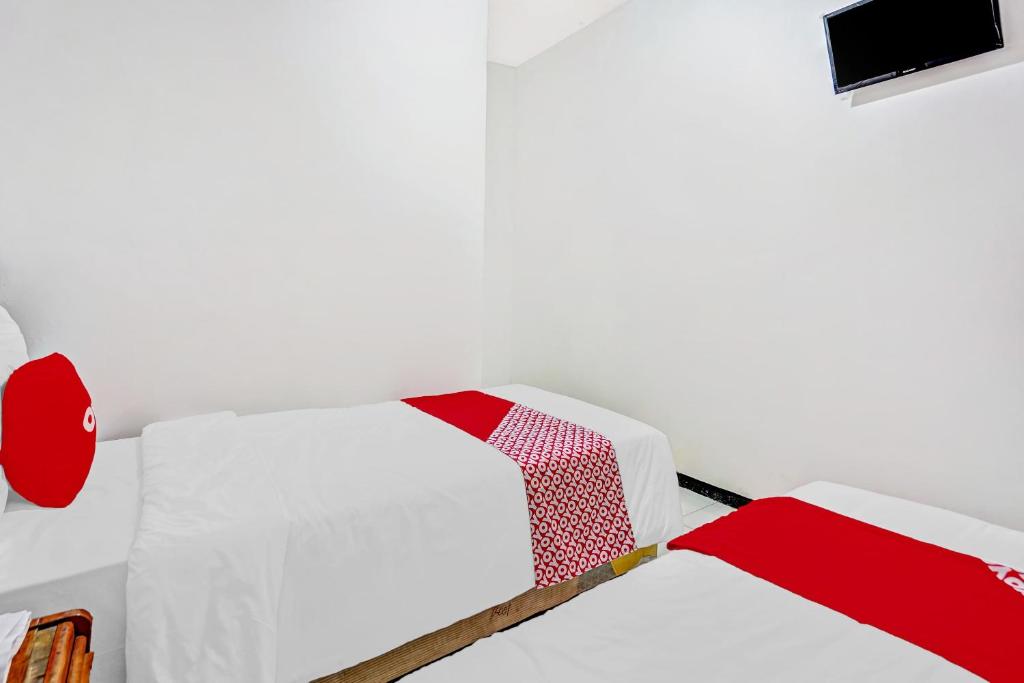 Postel nebo postele na pokoji v ubytování Hotel Kalimantan Surabaya Syariah